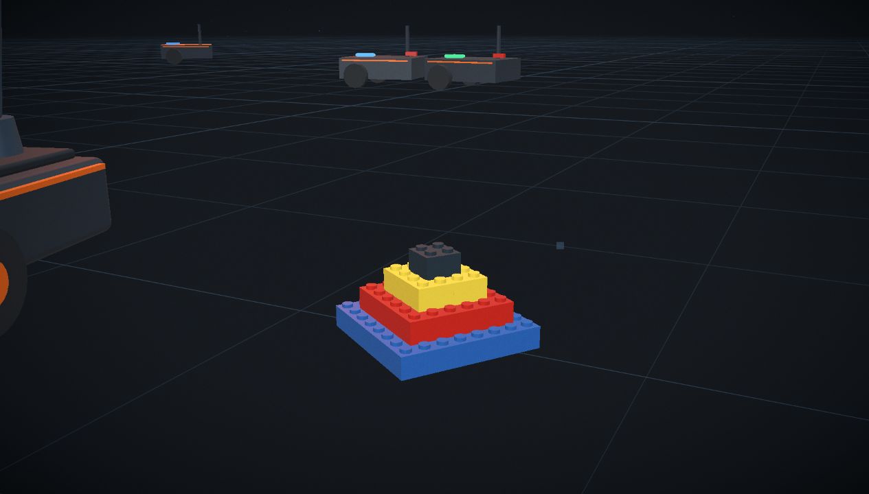 The finished thirteen-brick pyramid on the build floor, a worker alongside it.